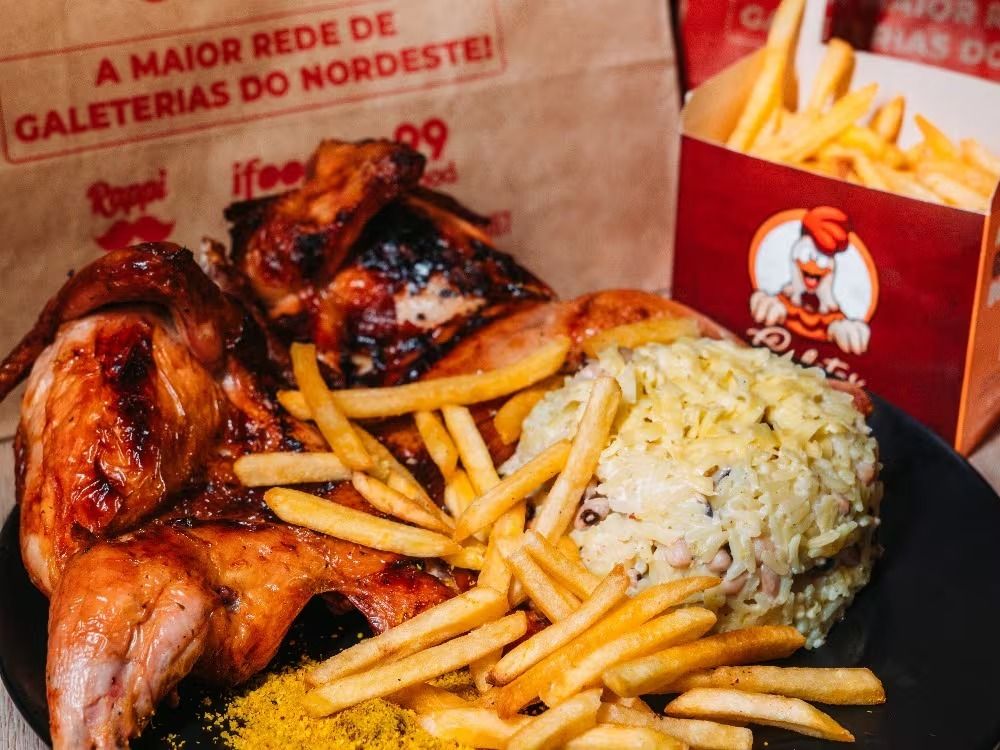 Mesa farta com galeto assado na brasa, baião de dois e batata frita — Galetos do Brasil em Fortaleza